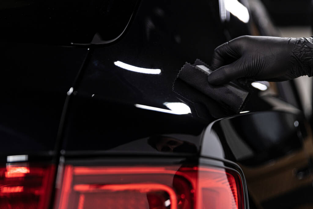 car detailing studio worker applying ceramic coating